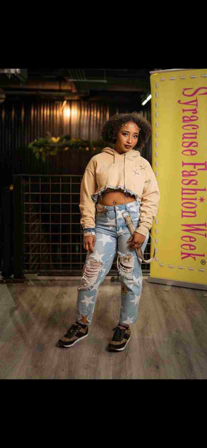a woman standing on a wooden floor wearing ripped jeans.