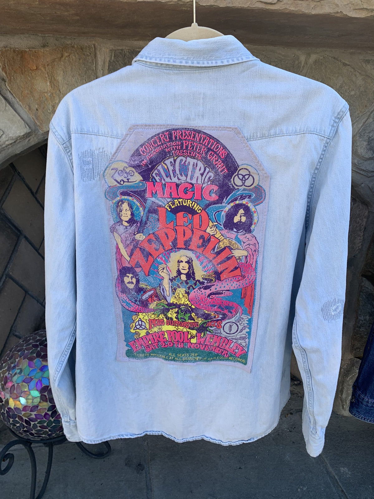 a blue jean jacket with a concert poster on it.
