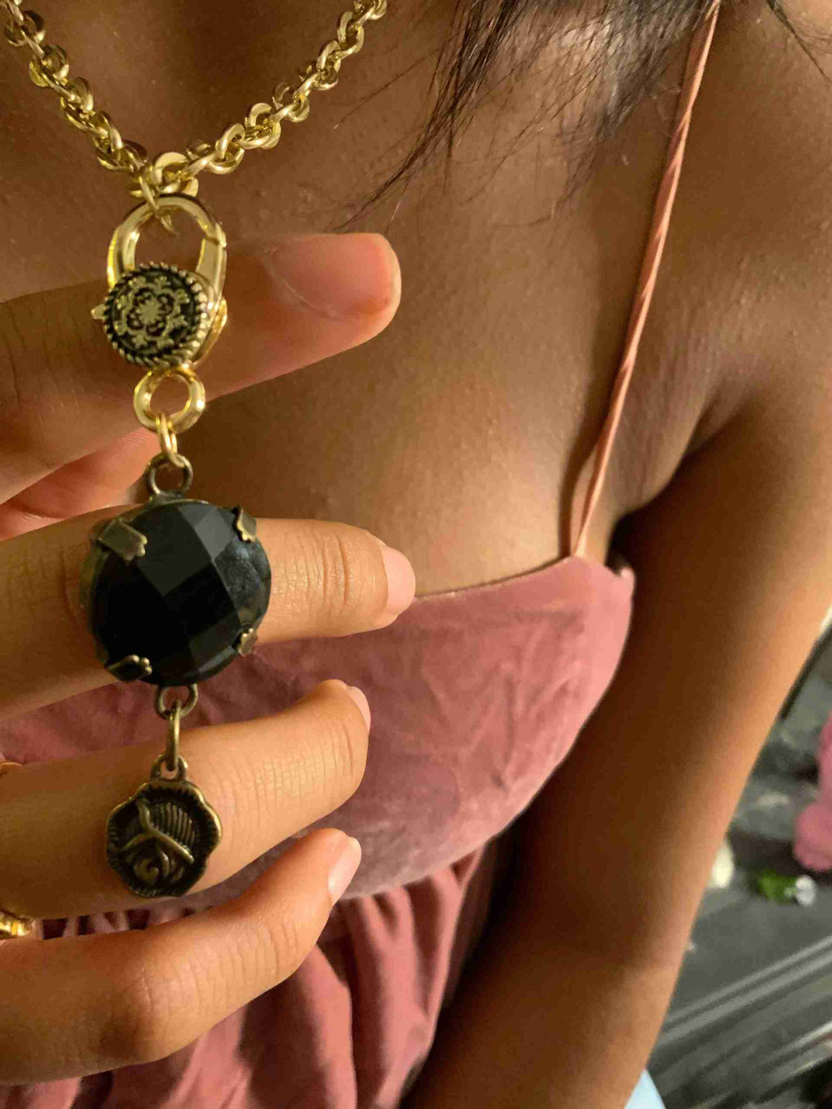 a woman wearing a necklace and a ring.
