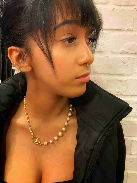 a woman wearing a black jacket and a necklace.