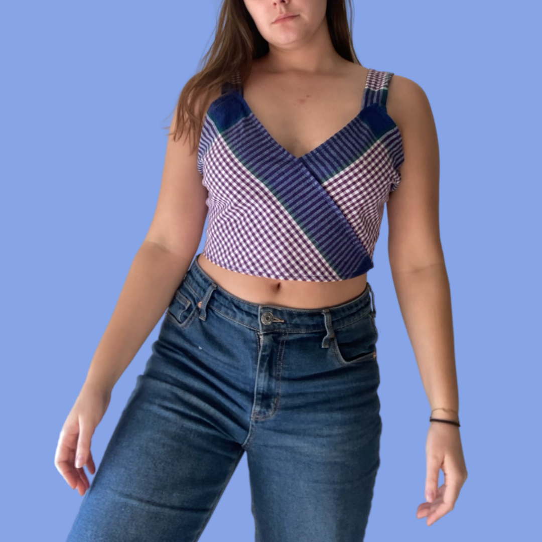 A woman wearing jeans and a plaid top.