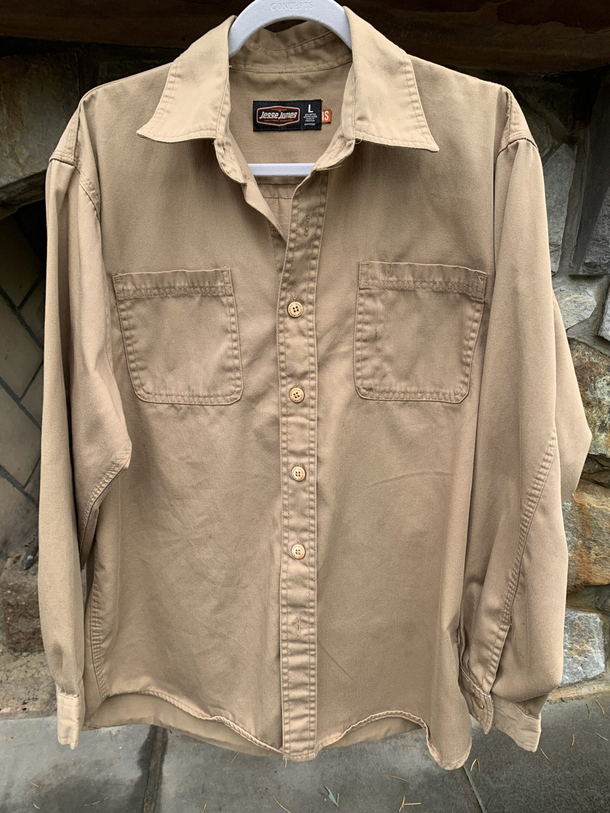 a tan shirt hanging on a clothes rack.