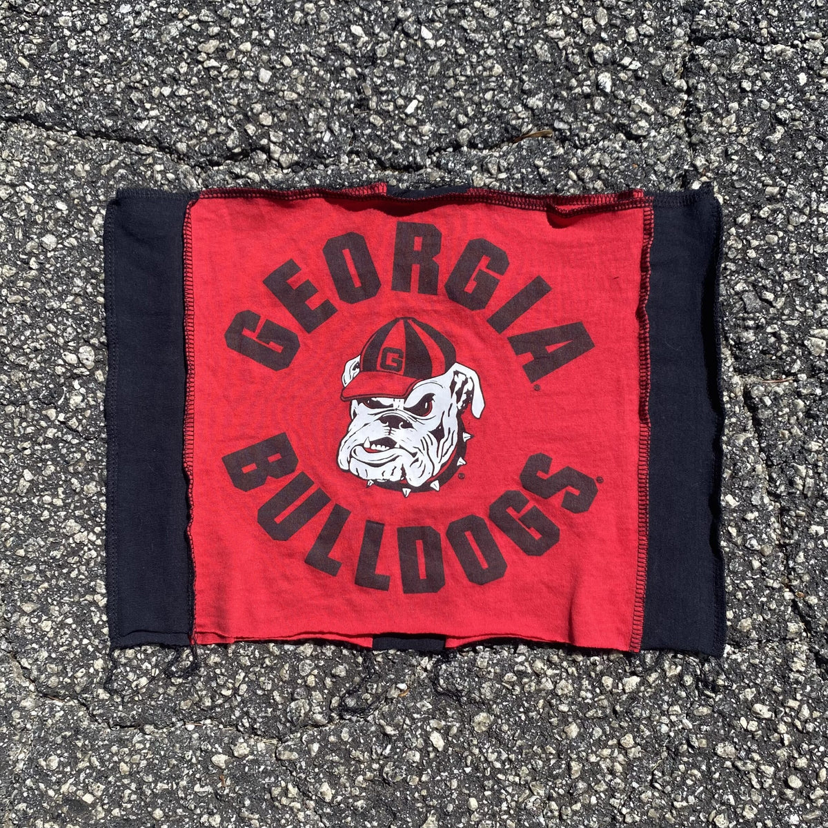 a red and black bandana laying on the ground.