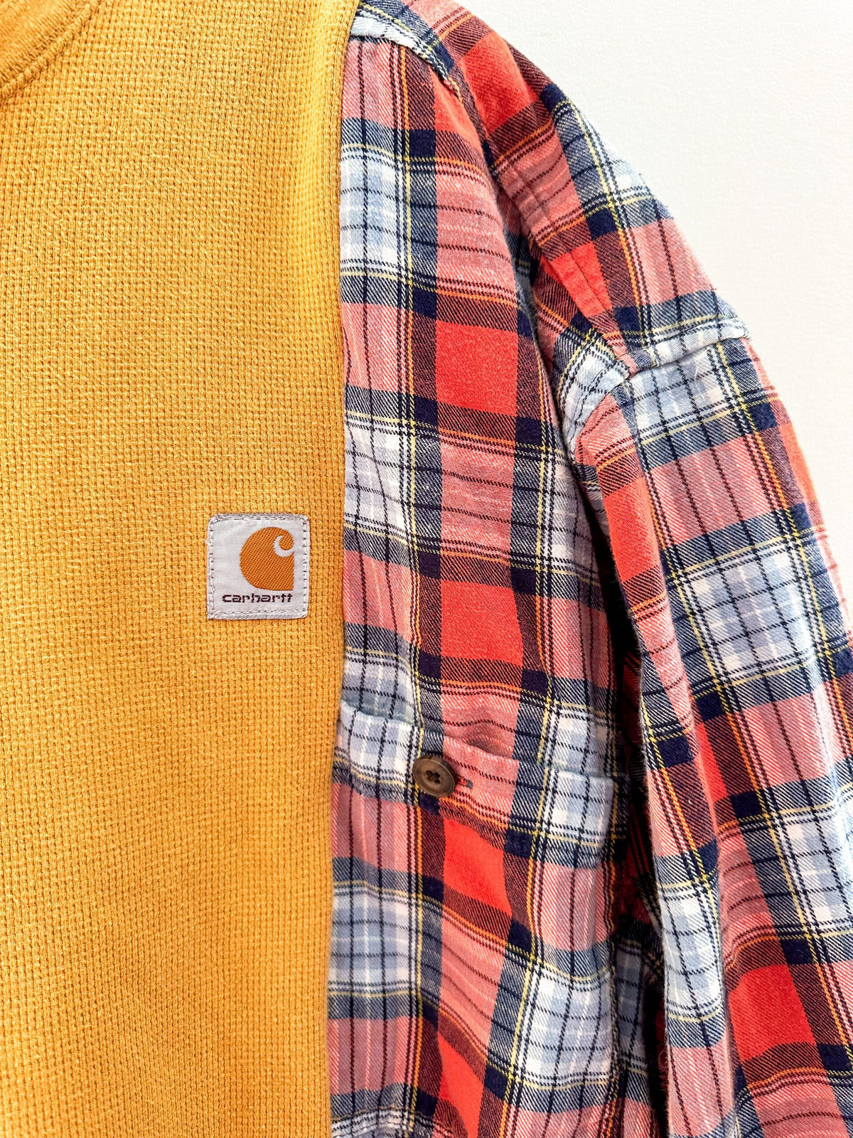 A carhartt flannel shirt with a patch on it.