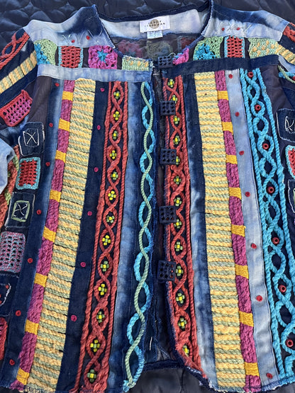 A denim jacket with colorful embroidery on it.