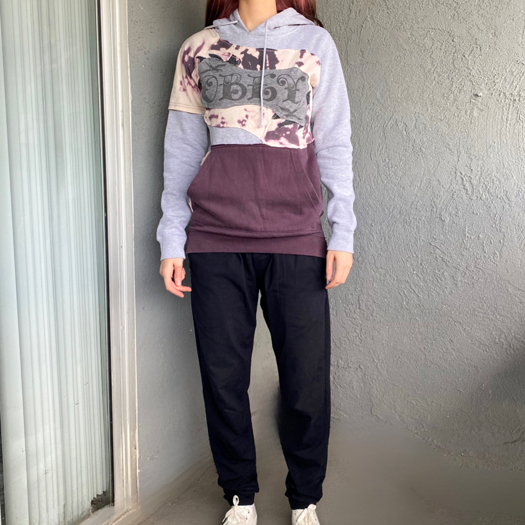 A woman wearing a purple hoodie and black pants.