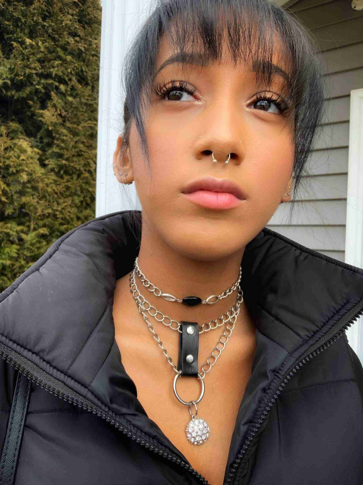 a woman with black hair wearing a black jacket.