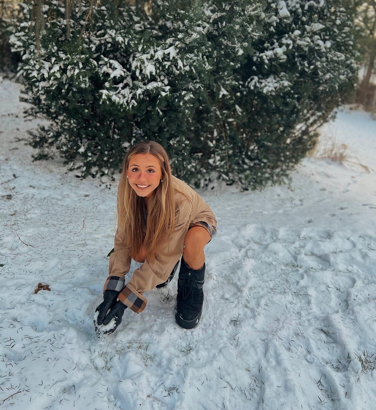 a woman kneeling in the snow with a pair of Out in the Country 2pc set (Camel Flannel paired with 70s tawny earth tone stripes) boots.