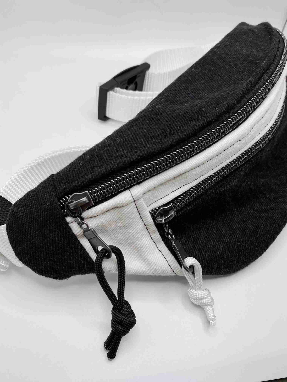 a black and white fanny bag on a white surface.
