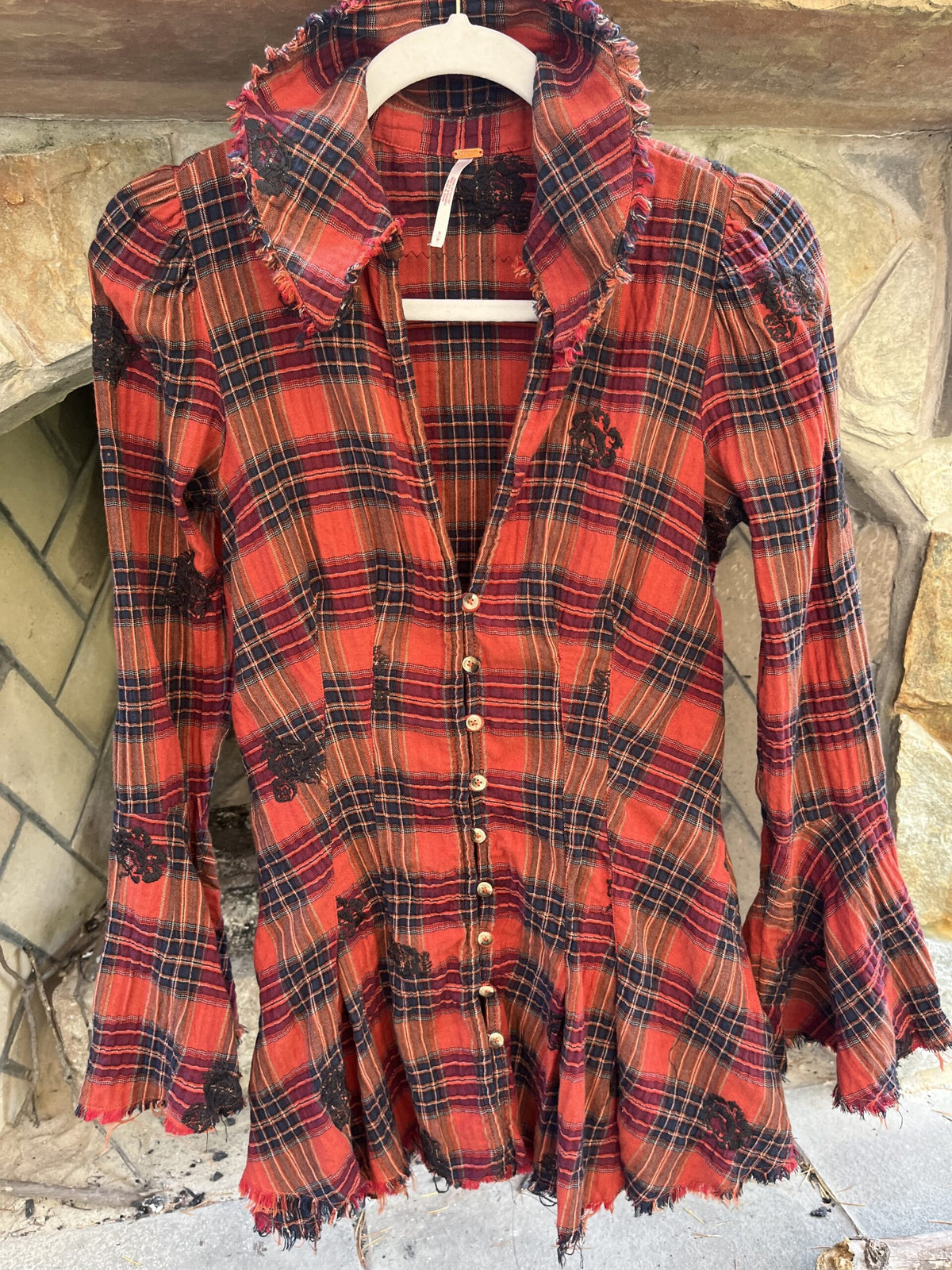 a red and black plaid shirt on a hanger.