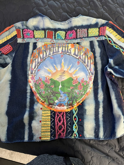 A woman is wearing a jacket with a tie dye design on it.
