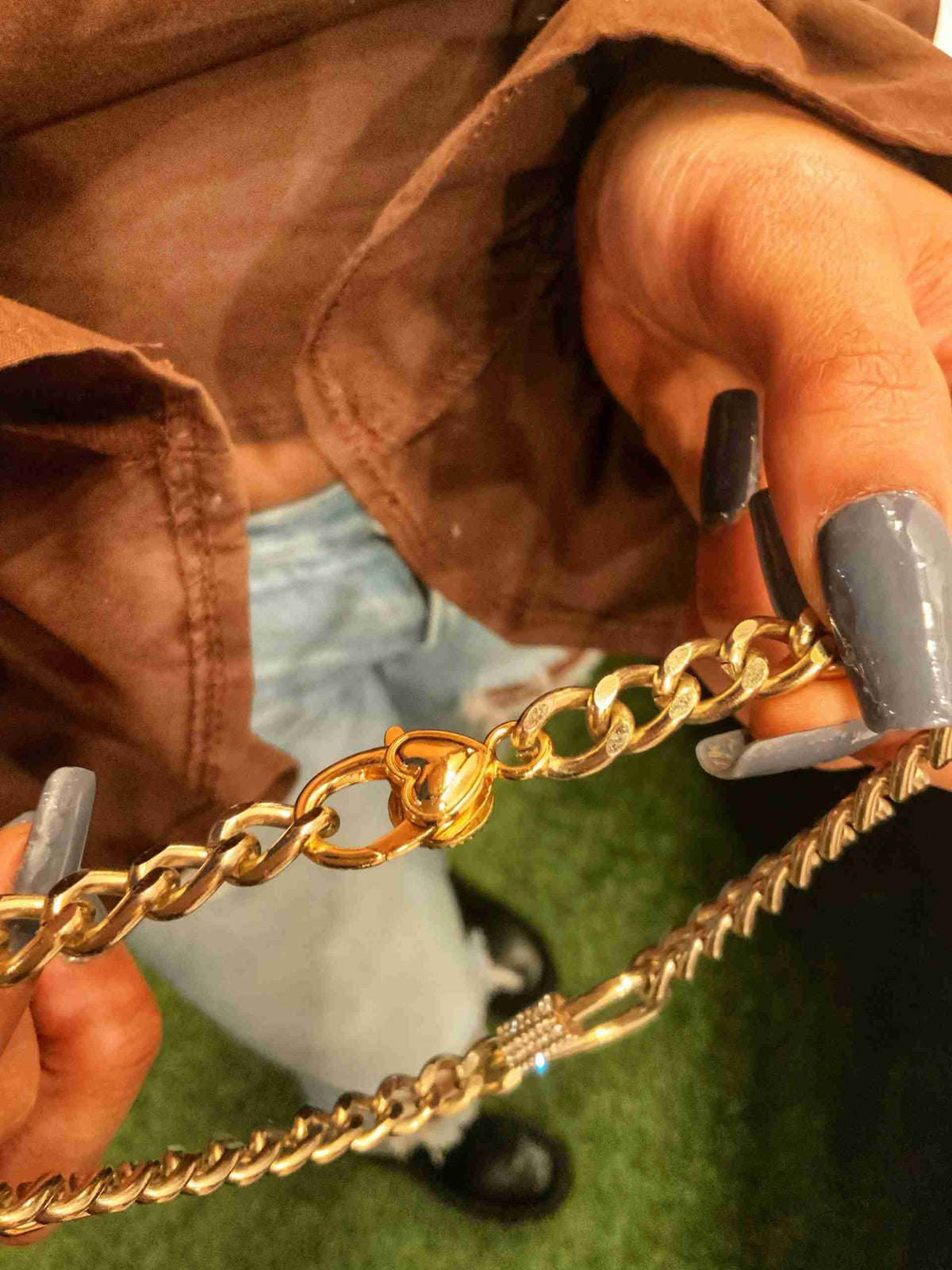 a person is holding a chain with a phone in their hand.