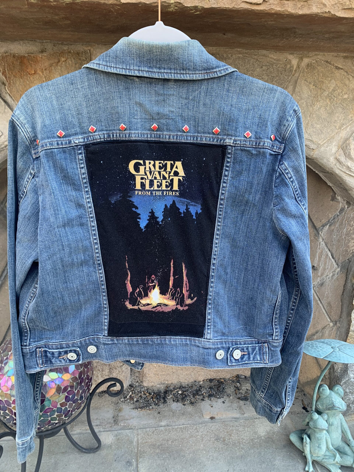 A Greta Van Fleet Denim Jacket with a picture of a campfire on it.