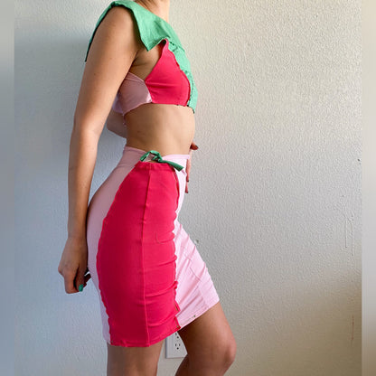 A woman in a 1of1 mint pink berry crop top and skirt set.