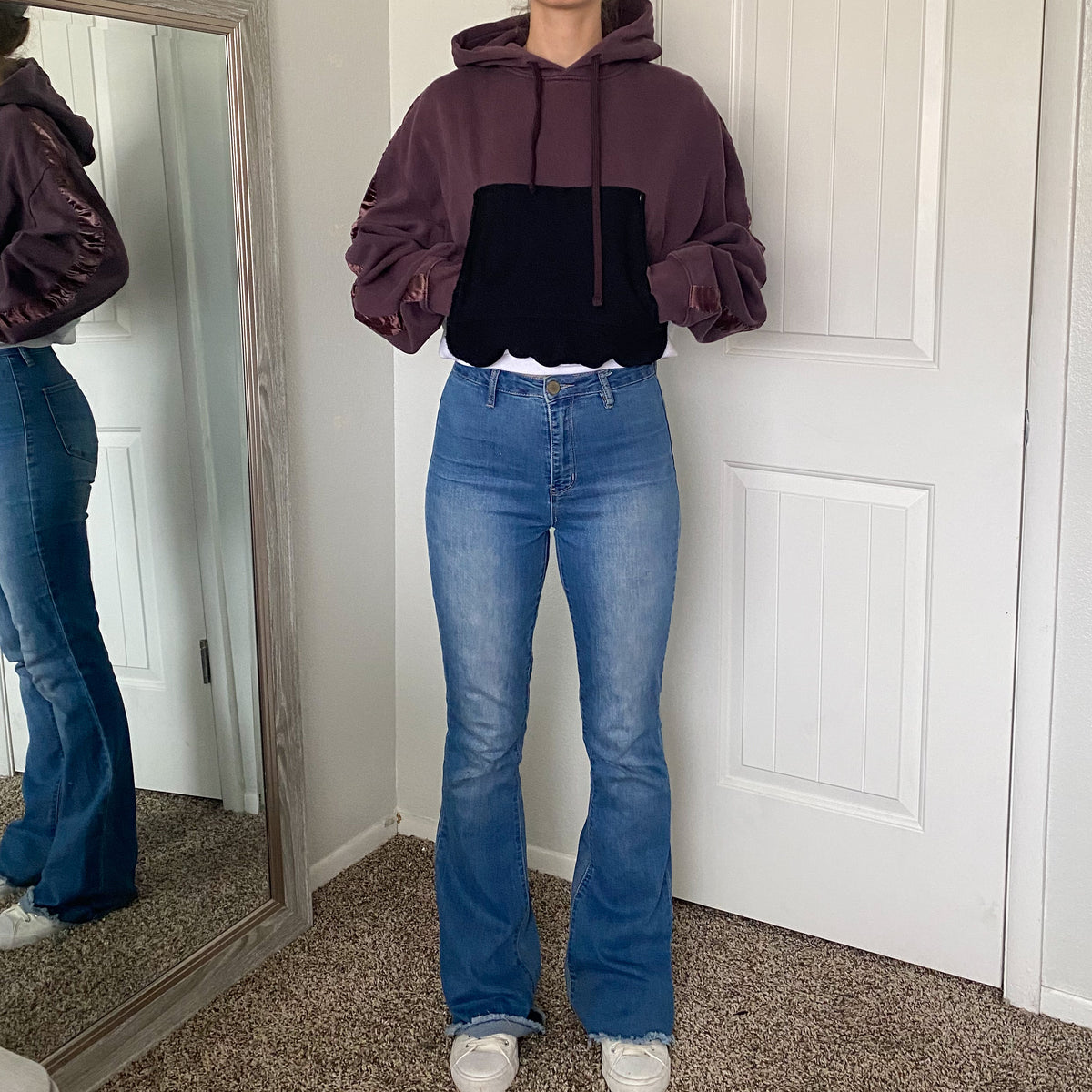 A woman standing in front of a mirror.