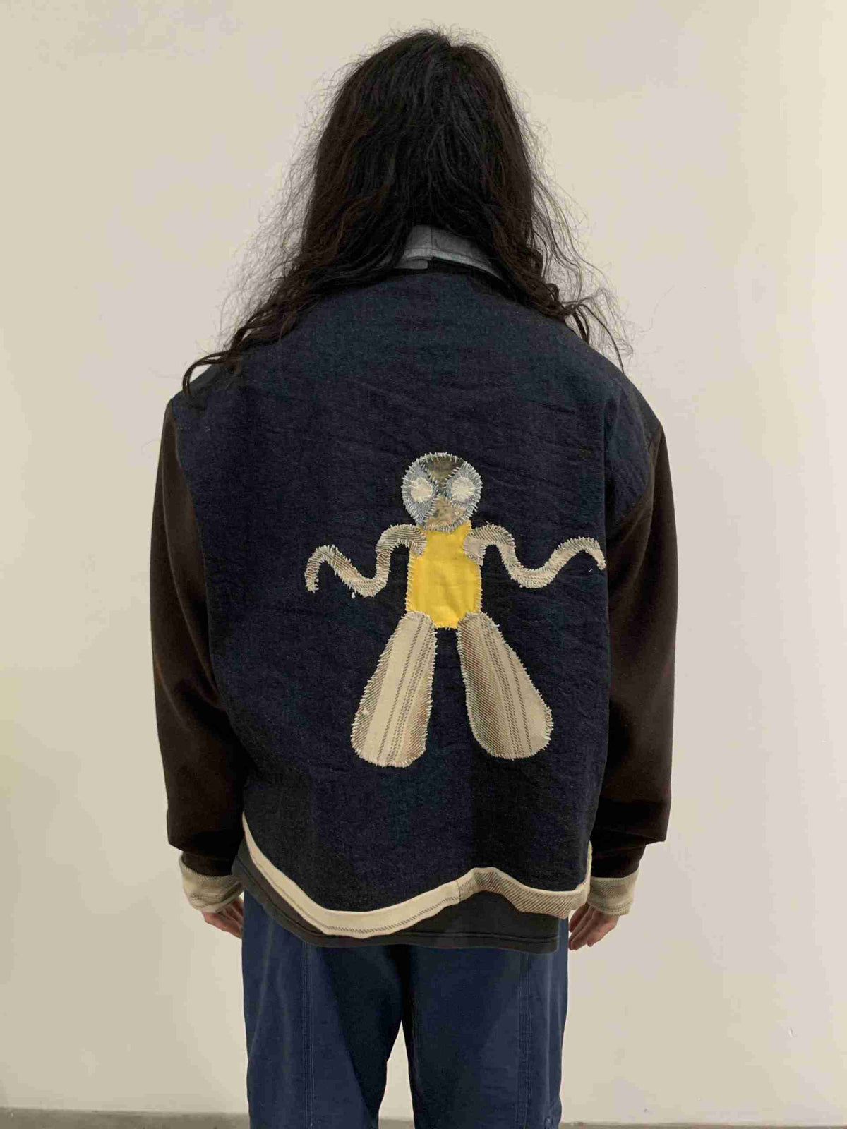 a person wearing a jacket with a picture of a mosquito on it.