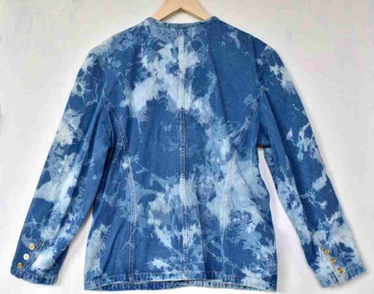 a blue jean jacket hanging on a white wall.
