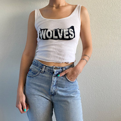 A woman wearing a white 1of1 wolves tank top.