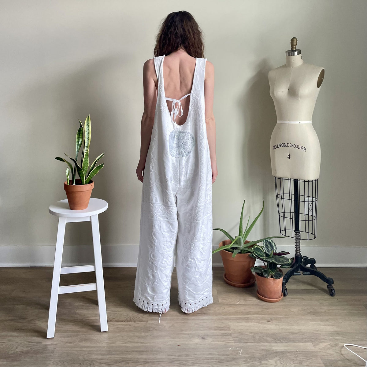 a woman standing in front of a mannequin.