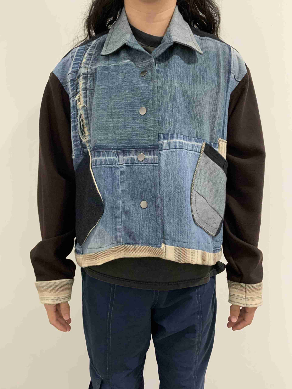 a person wearing a jean jacket with a patch on the back.