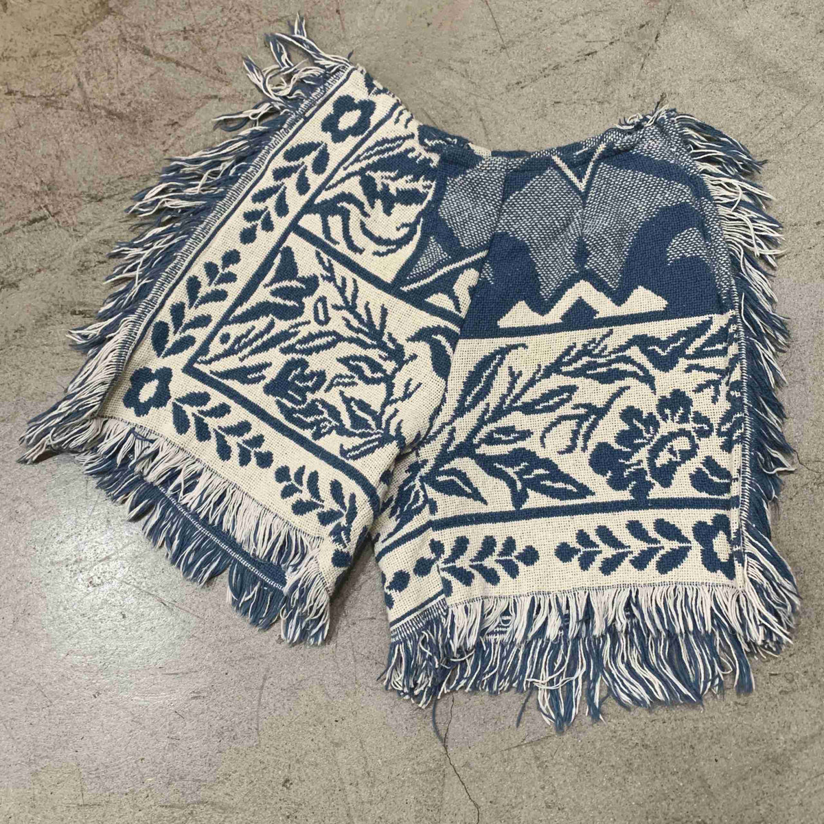 a blue and white blanket laying on a floor.