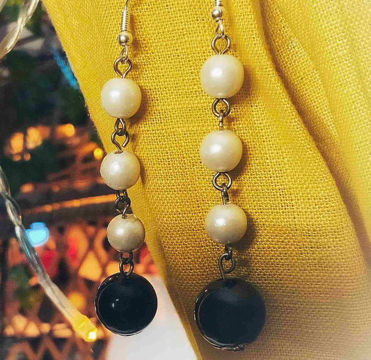 a close up of a pair of earrings on a mannequin.