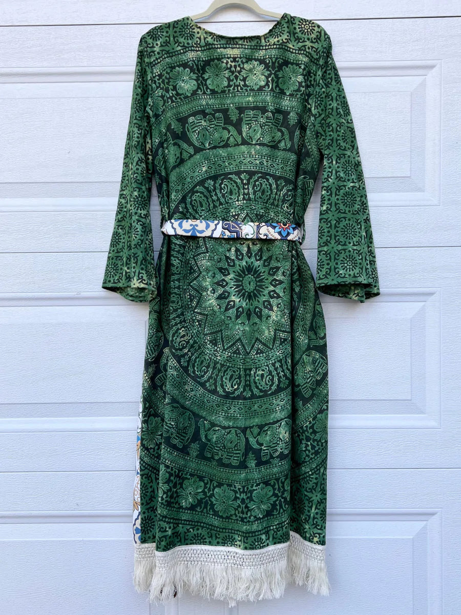 a green dress hanging up against a garage door.