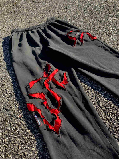 a pair of black pants with red ribbons on them.
