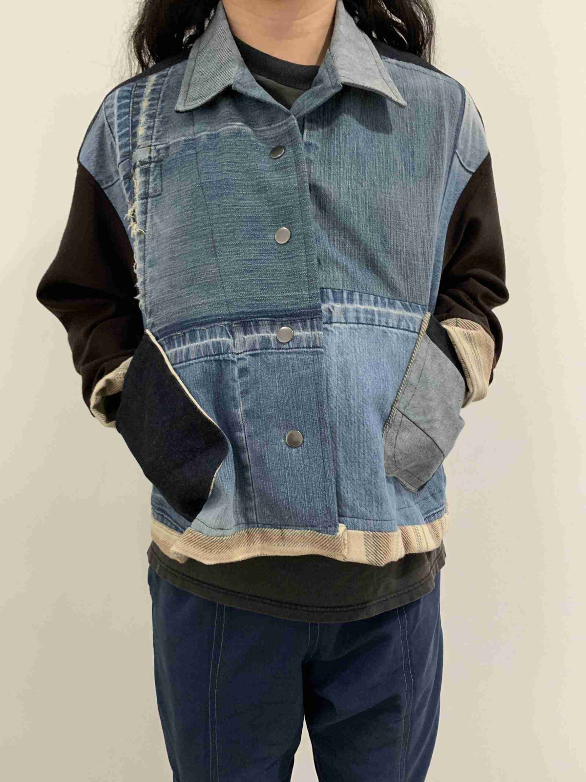 a young girl wearing a jean jacket and jeans.