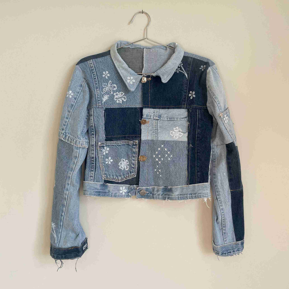 a jean jacket hanging on a wall.