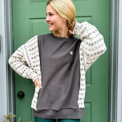 a woman standing in front of a green door wearing a Reworked Vintage Champion Neutral Crewneck.
