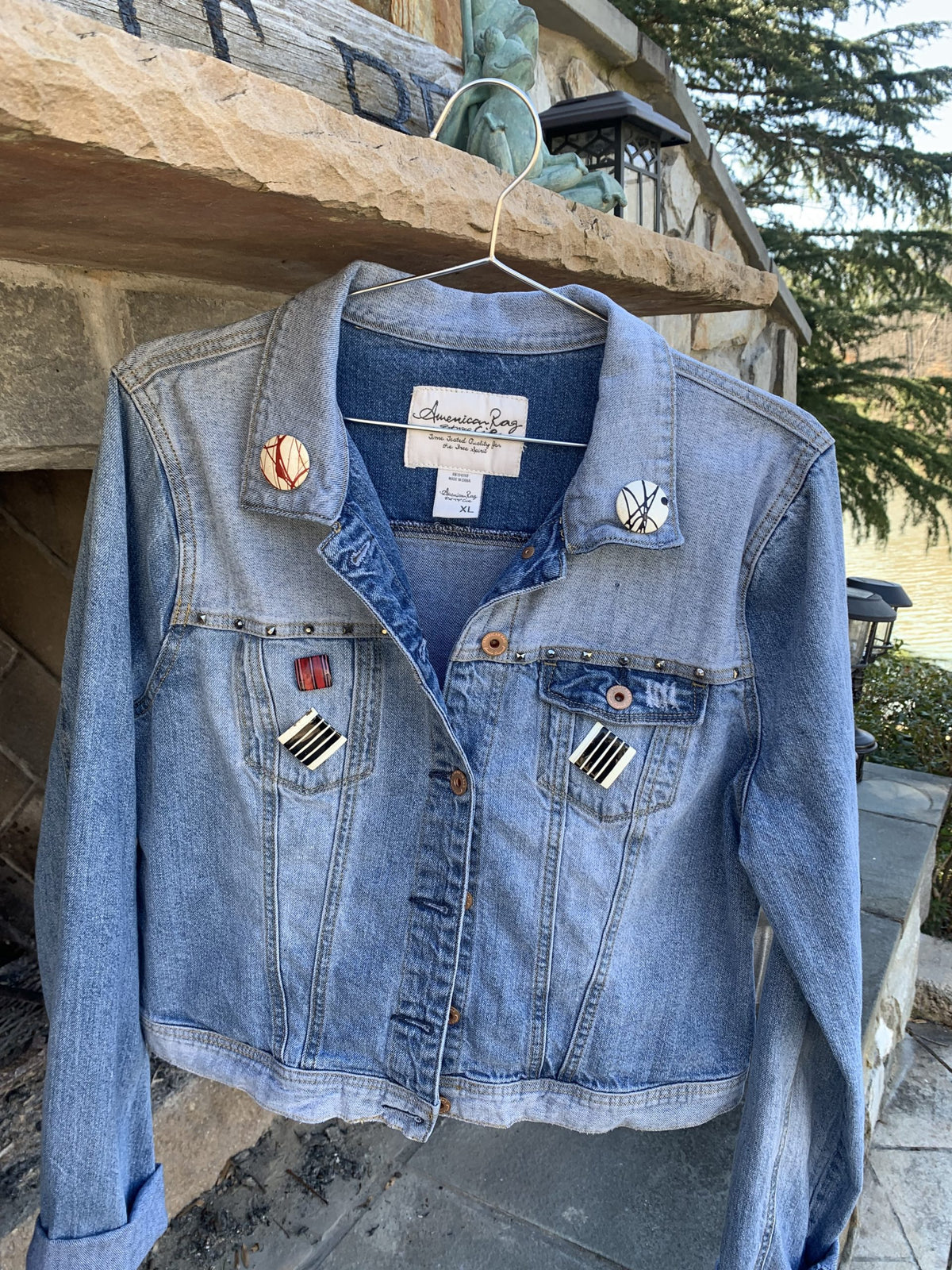 A Rolling Stones Denim Jacket hanging on a clothes rack.