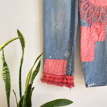A pair of patched jeans hanging on a wall.