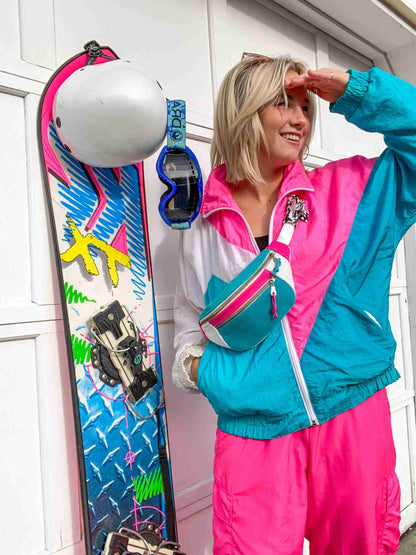 a woman standing next to a wall holding a snowboard.