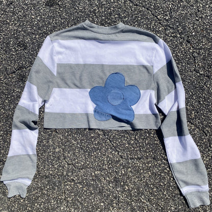 a striped shirt with a blue flower on it.