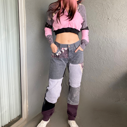 A woman wearing a pink crop top and grey pants.