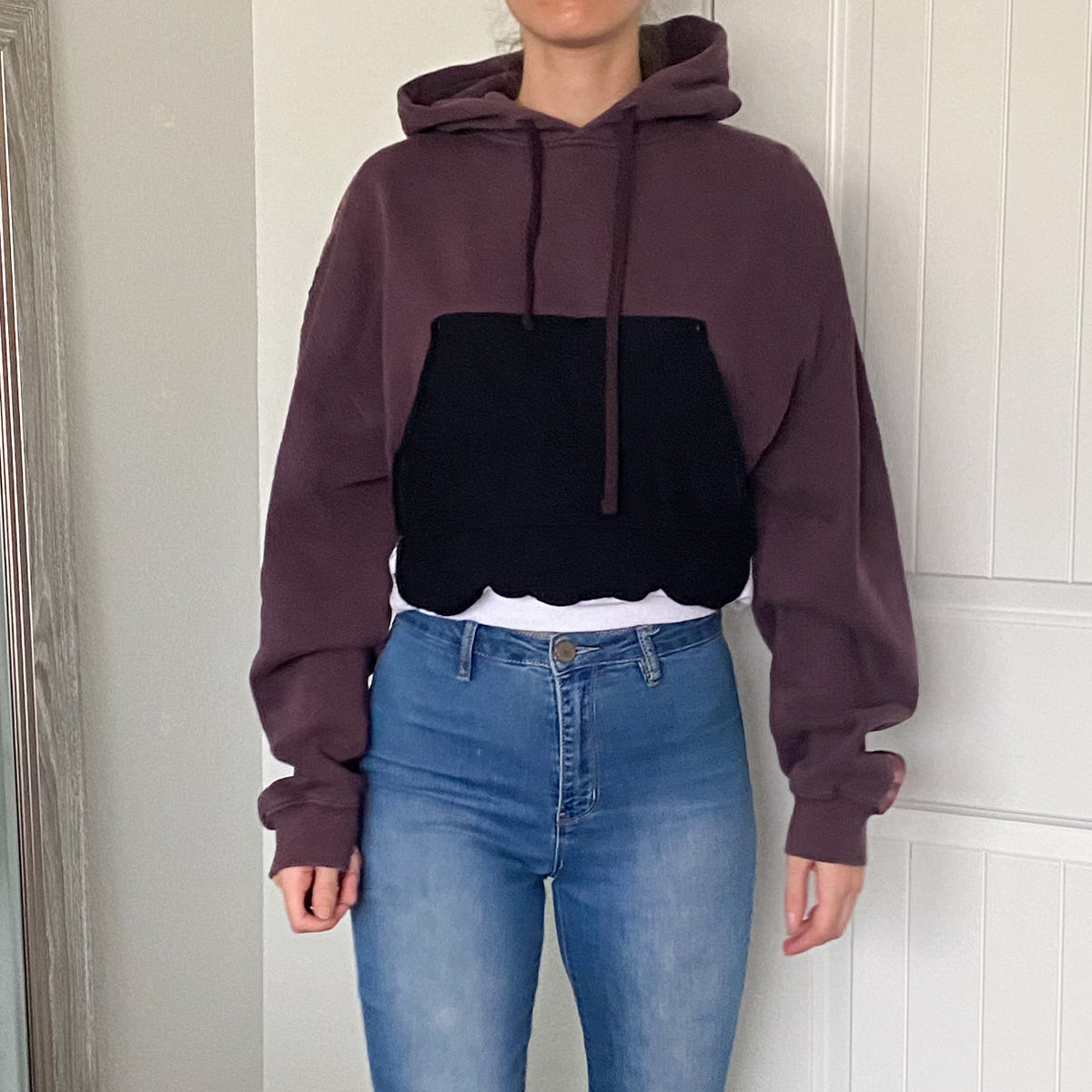 A woman wearing jeans and a hoodie.