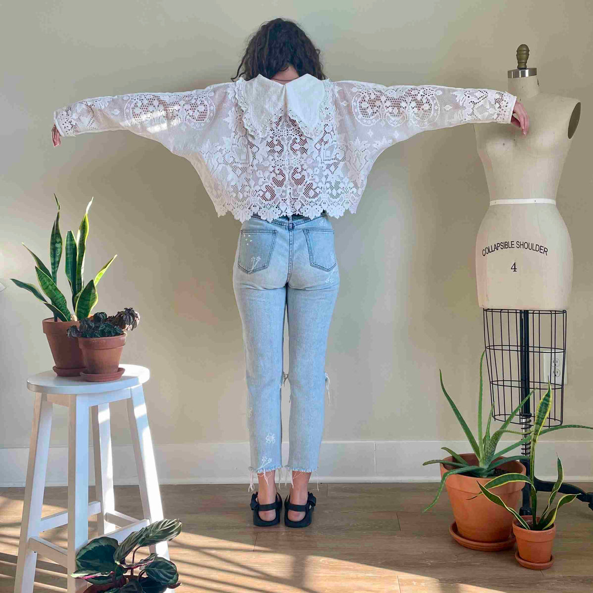 a woman standing in front of a mannequin.