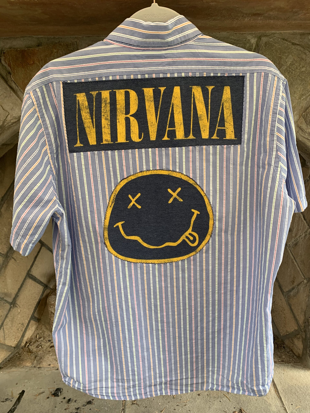 A Nirvana mens pinstriped button up shirt with a smiley face on it.