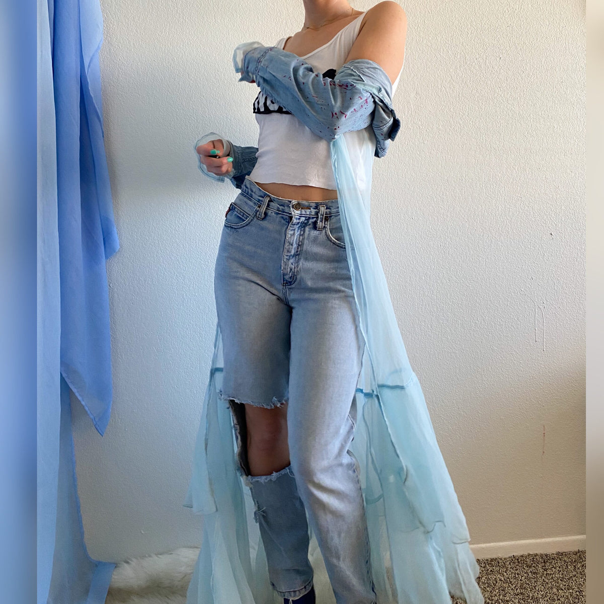 A woman in a 1of1 fairytale feels jacket and blue jeans.