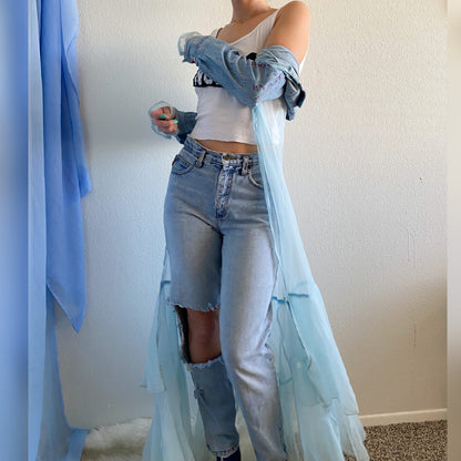 A woman in a 1of1 fairytale feels jacket and blue jeans.