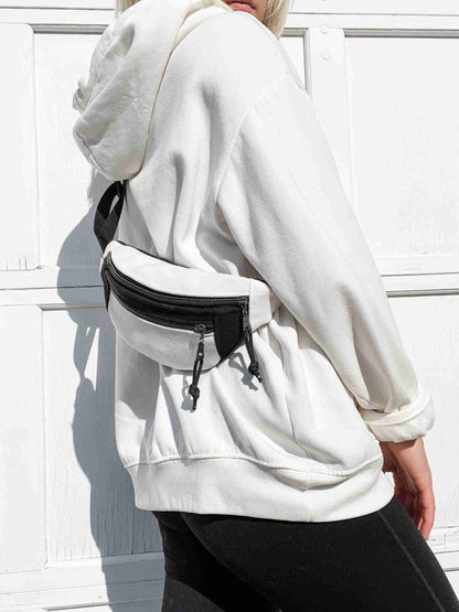 a woman wearing a white hoodie and black pants.