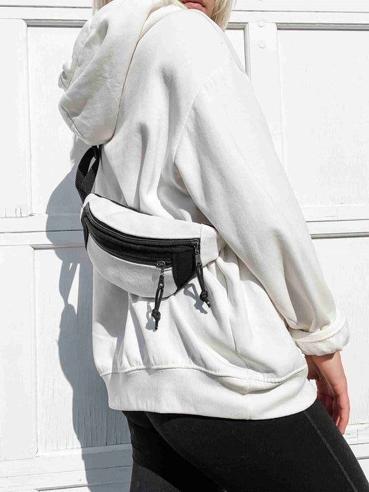 a woman wearing a white hoodie and black pants.