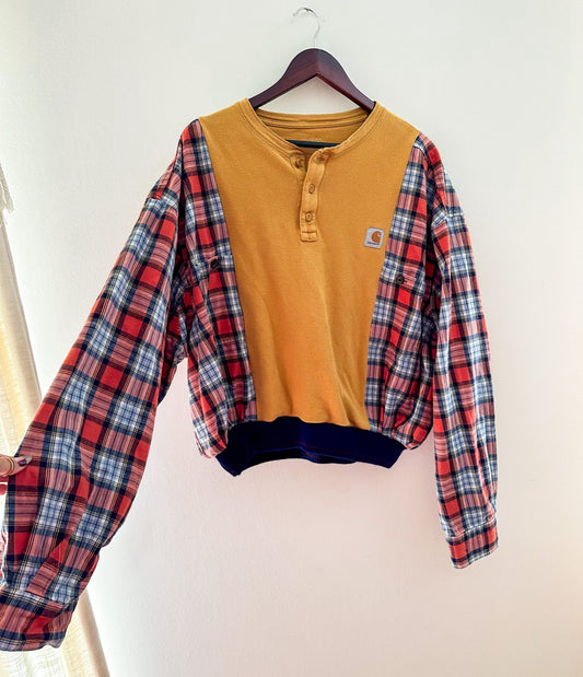 A yellow and blue plaid sweater hanging on a wall.