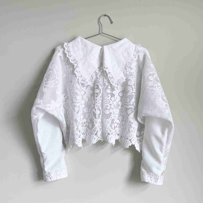 a white blouse hanging on a hanger.