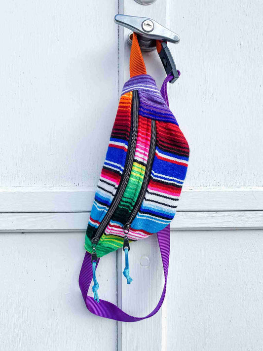 a colorful backpack hanging on a white door.