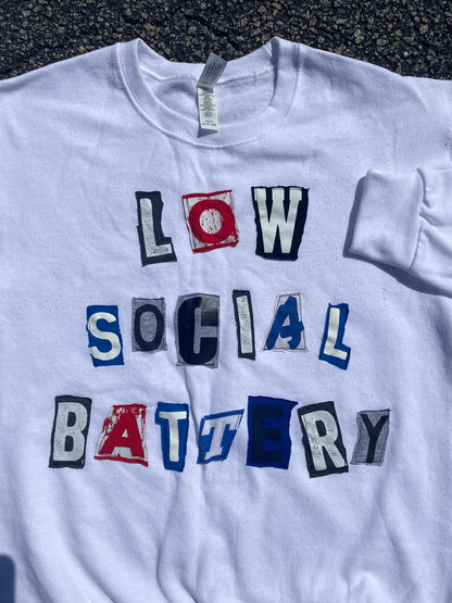 a white t - shirt that says low social battery.