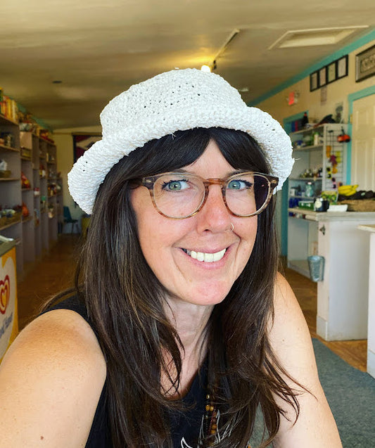 A woman wearing glasses and a white hat.
