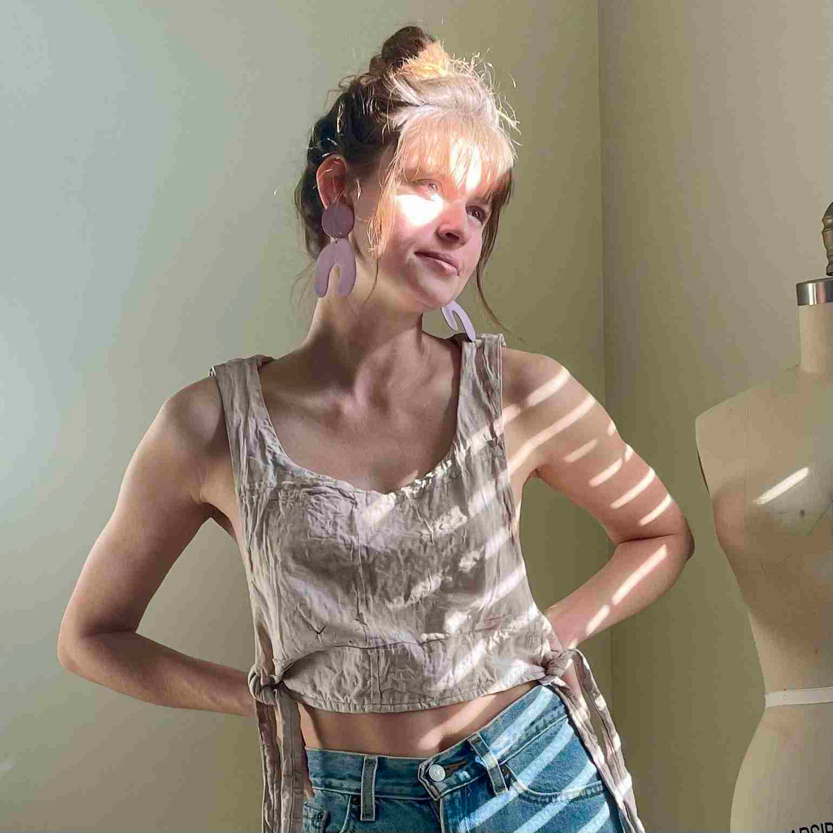 a woman standing in front of a mirror with her hands on her hips.