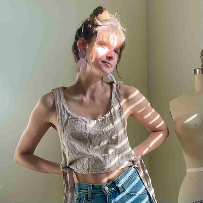 a woman standing in front of a mirror with her hands on her hips.